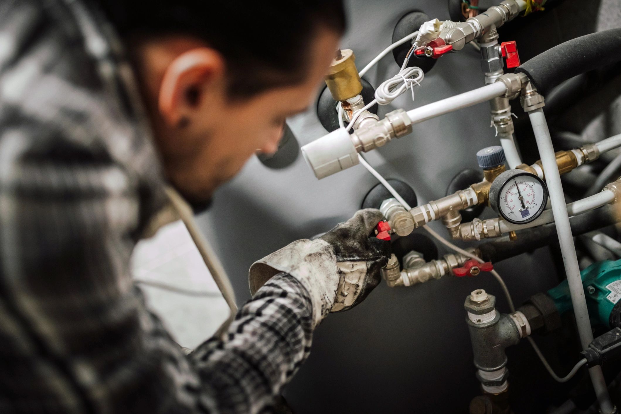 Plumber tightening a water line fitting
