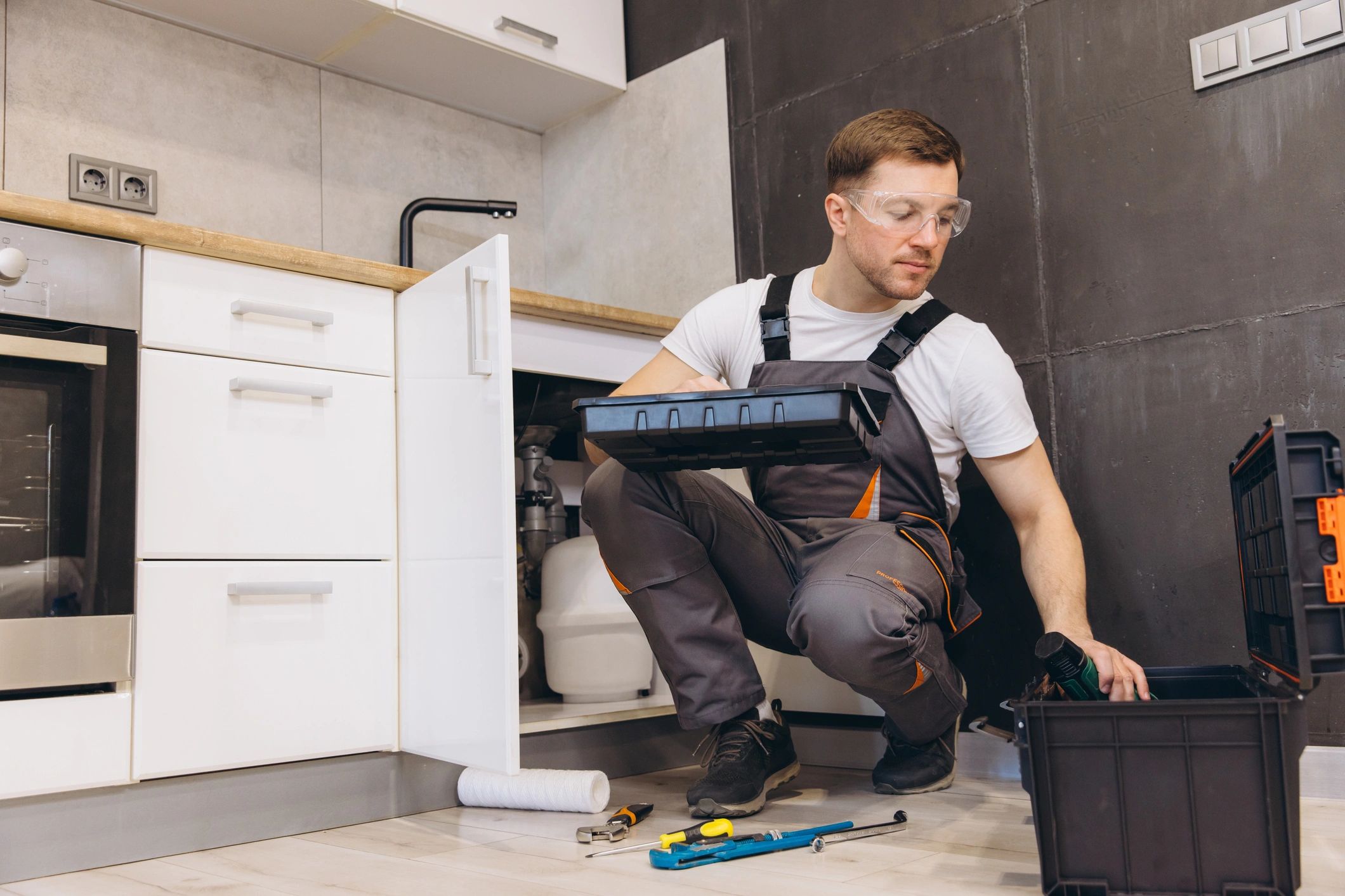 Plumber working under a kitchen sink