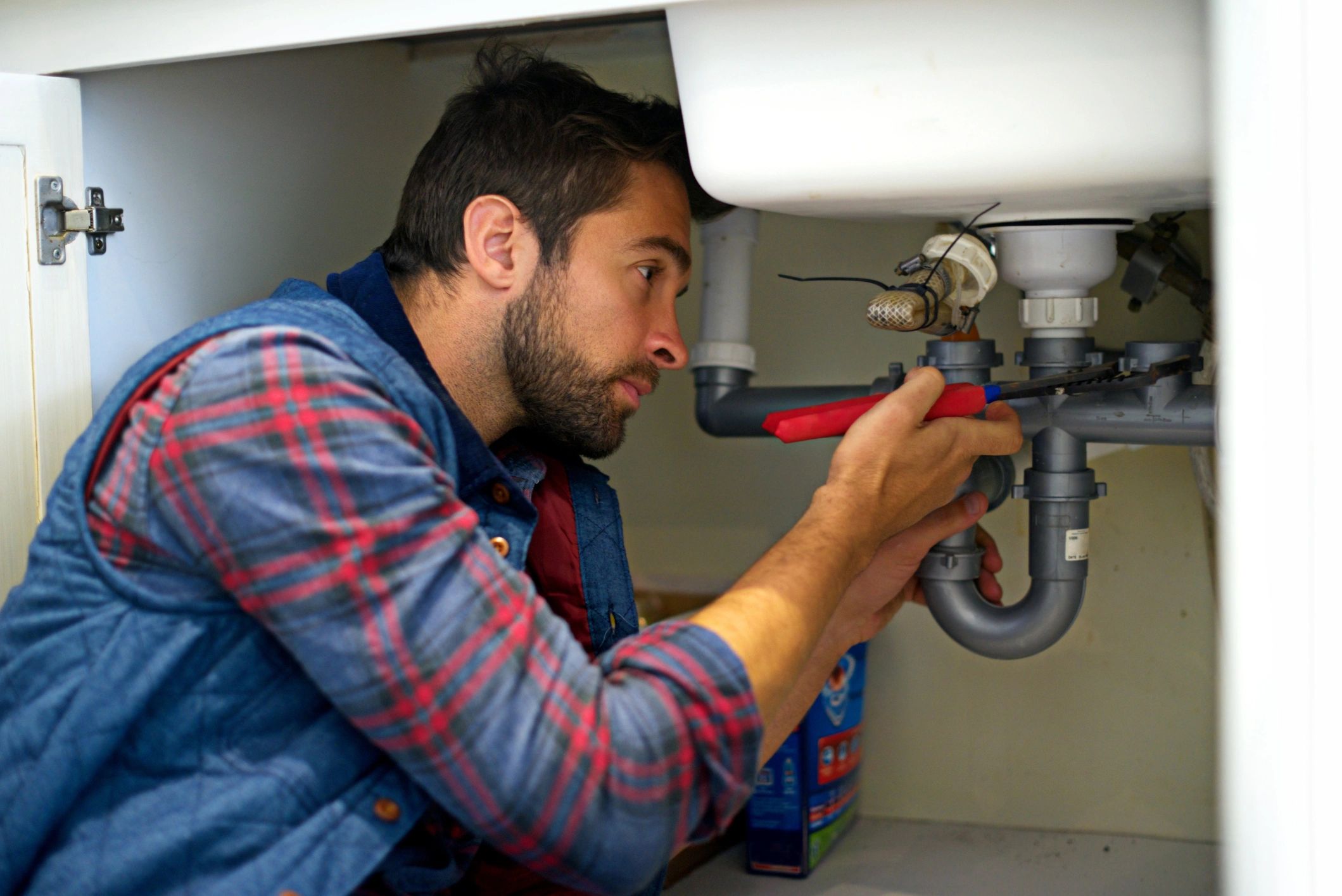 Plumber working on pipes during a residential repair